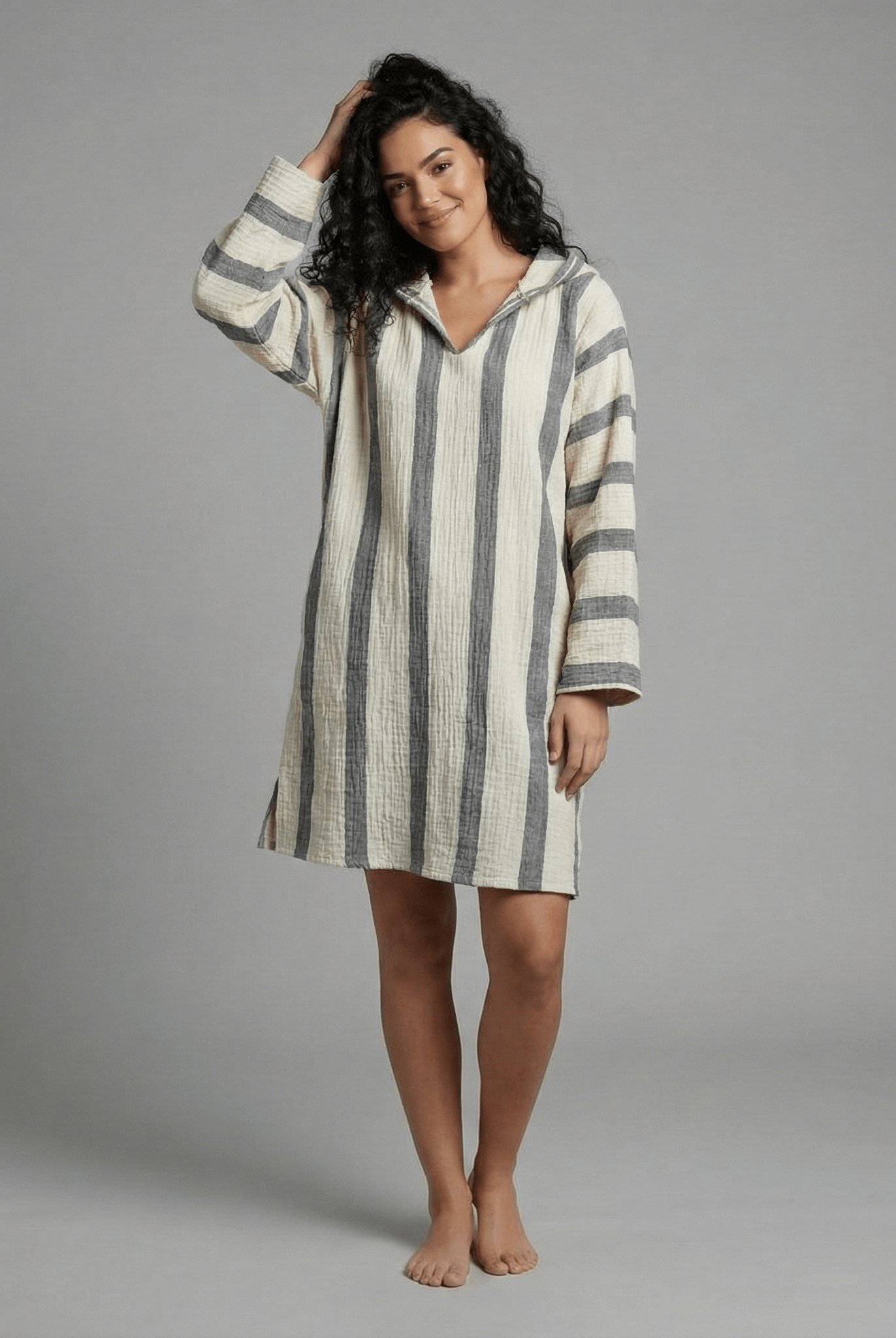 Woman wearing a striped dress against a gray background