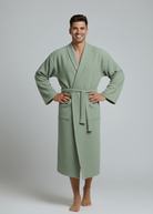 Man wearing a green waffle robe against a plain background