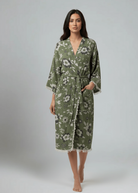 Woman wearing a green floral robe on a gray background